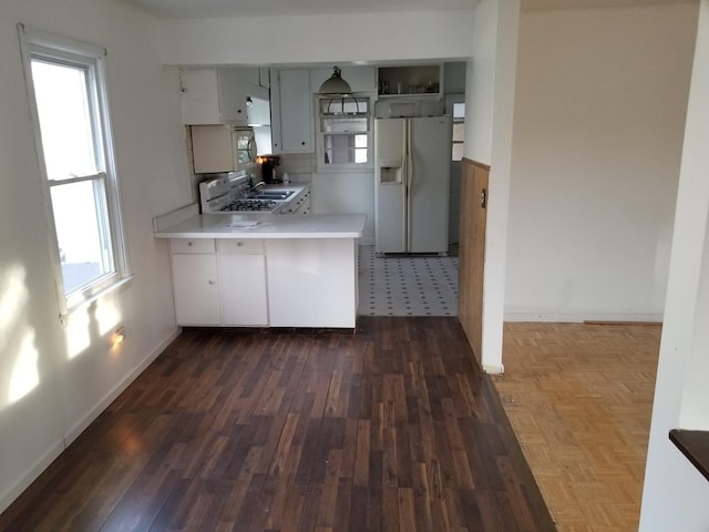 kitchen featuring kitchen peninsula, dark hardwood / wood-style flooring, white fridge with ice dispenser, and sink