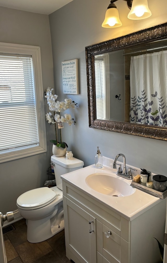 bathroom featuring tile flooring, vanity with extensive cabinet space, and toilet