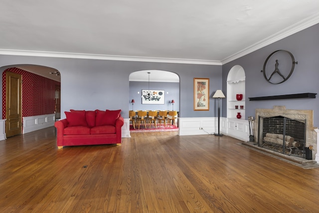 living room with dark hardwood / wood-style floors, ornamental molding, and built in shelves