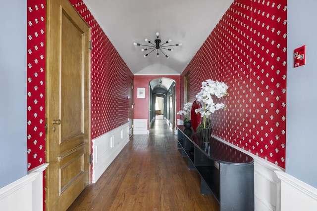 hallway with dark hardwood / wood-style floors and vaulted ceiling