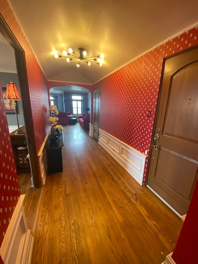 corridor featuring ornamental molding and wood-type flooring