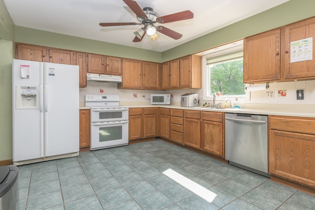 kitchen with white appliances, sink, light tile flooring, and ceiling fan