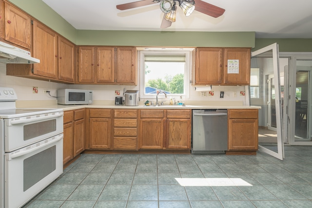 kitchen featuring white appliances, sink, tasteful backsplash, light tile flooring, and ceiling fan