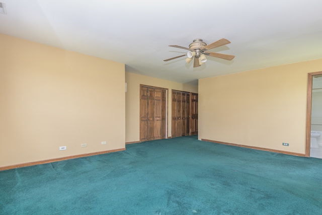 spare room with ceiling fan and dark carpet