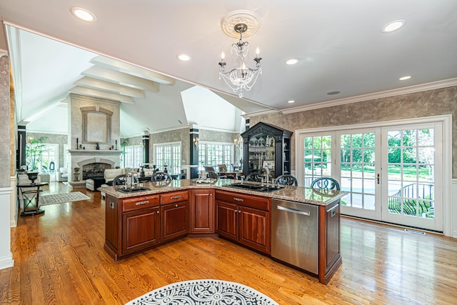 kitchen featuring ornamental molding, a fireplace, light wood-type flooring, and stainless steel dishwasher