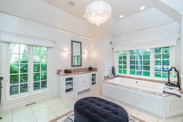 bathroom featuring an inviting chandelier, tile floors, a bathtub, high vaulted ceiling, and vanity