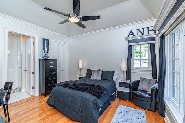 tiled bedroom featuring ceiling fan, crown molding, and ensuite bath