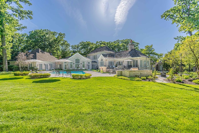 rear view of house with a yard and a patio area