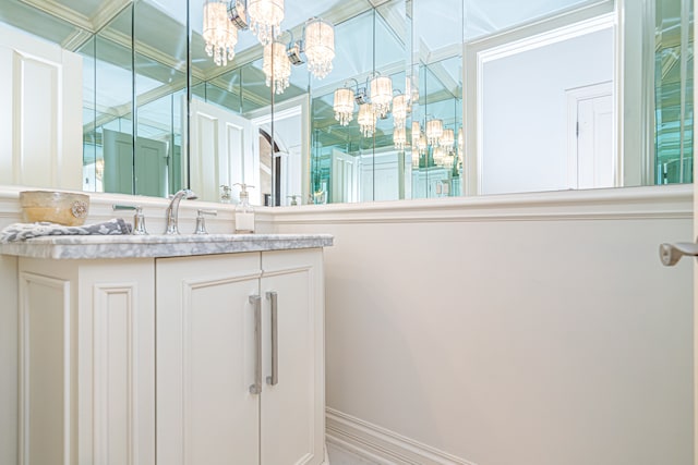 bathroom featuring a notable chandelier and vanity