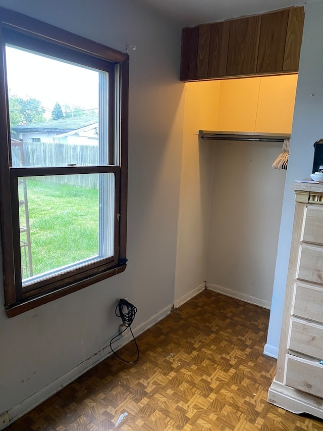 spare room with dark parquet flooring and plenty of natural light