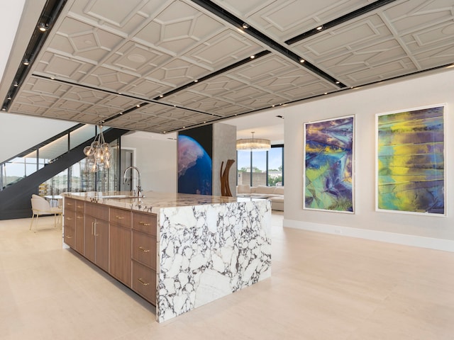 interior space featuring a chandelier, decorative light fixtures, sink, and light tile patterned floors