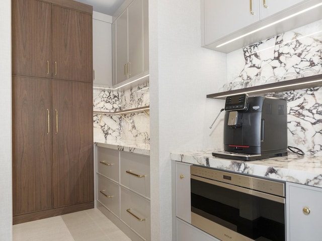 bar featuring wall oven, stainless steel microwave, and tasteful backsplash