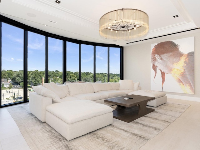 living area with an inviting chandelier, floor to ceiling windows, and a tray ceiling