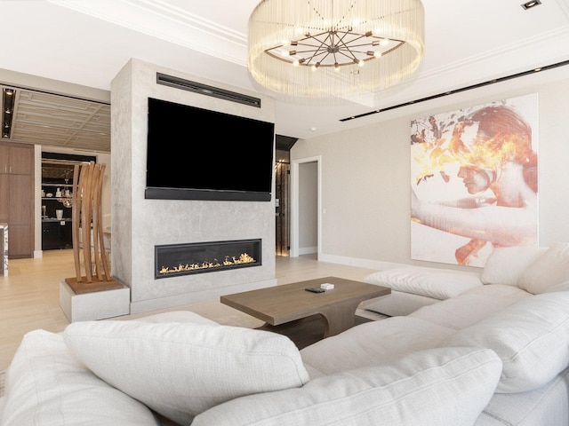 living room with crown molding, a barn door, a fireplace, and an inviting chandelier