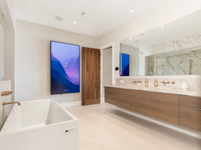 bathroom with a tub, dual vanity, tile patterned floors, and tasteful backsplash