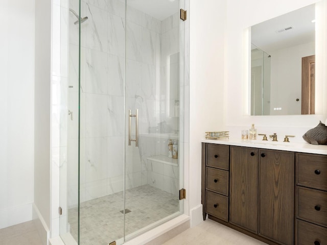 full bathroom featuring vanity, a shower stall, and visible vents