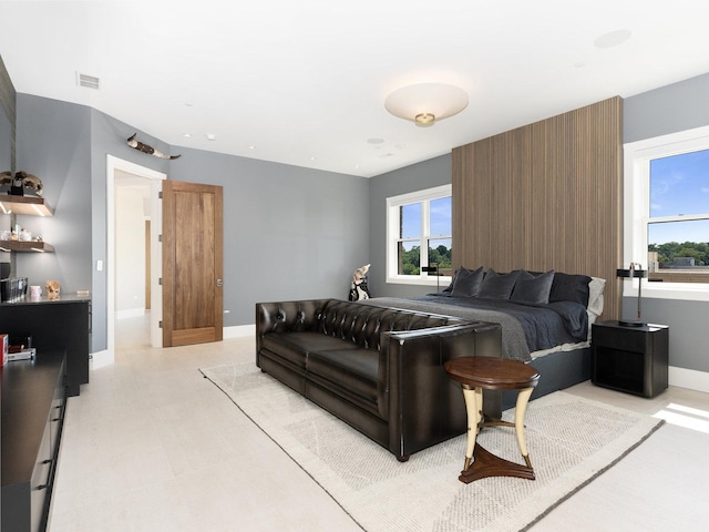 bedroom featuring baseboards, light floors, and visible vents