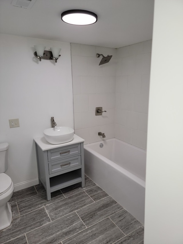 full bathroom with tiled shower / bath combo, vanity, and toilet