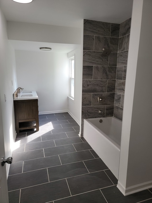 bathroom featuring tile patterned flooring, vanity, and tiled shower / bath