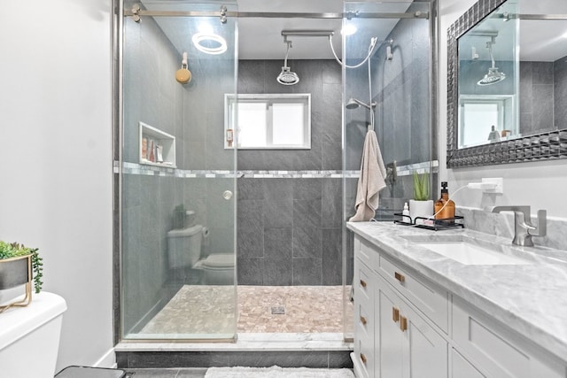 bathroom featuring an enclosed shower, vanity, and toilet