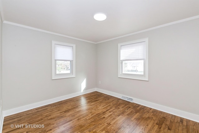 empty room with crown molding and wood-type flooring