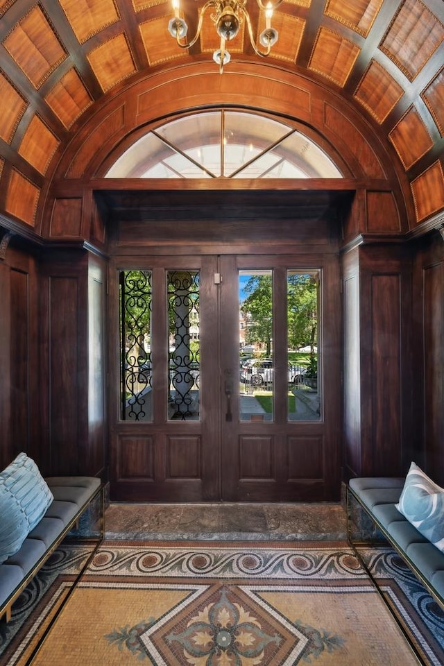 entrance foyer with wood walls, lofted ceiling, and brick ceiling