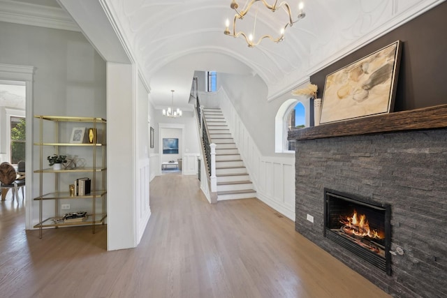 entryway with a fireplace, hardwood / wood-style flooring, an inviting chandelier, and a healthy amount of sunlight