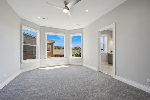 unfurnished bedroom featuring ceiling fan, light colored carpet, and connected bathroom