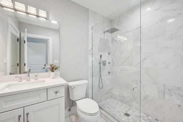 bathroom with vanity, toilet, and a tile shower