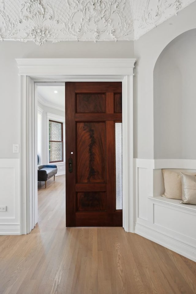 hallway featuring light wood-type flooring and crown molding