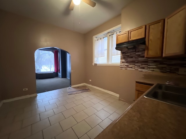 kitchen featuring light tile patterned floors, light brown cabinets, sink, decorative backsplash, and ceiling fan