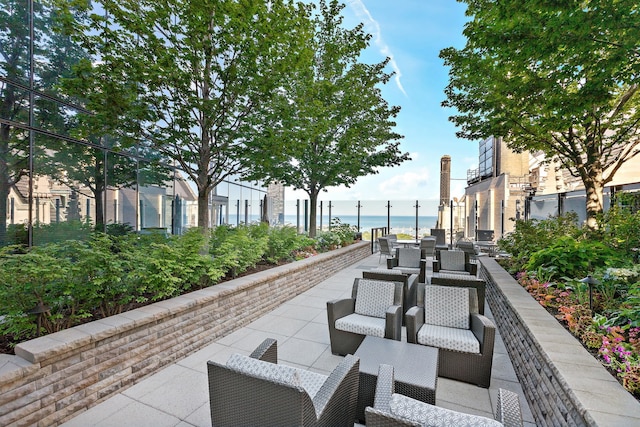 surrounding community featuring a water view and a patio area