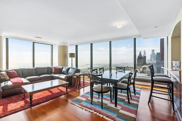 living room with a water view, a wealth of natural light, expansive windows, and wood-type flooring