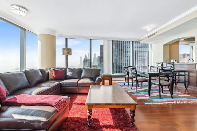 living room with a wall of windows, hardwood / wood-style floors, plenty of natural light, and ornamental molding