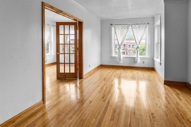 spare room with light wood-type flooring and crown molding