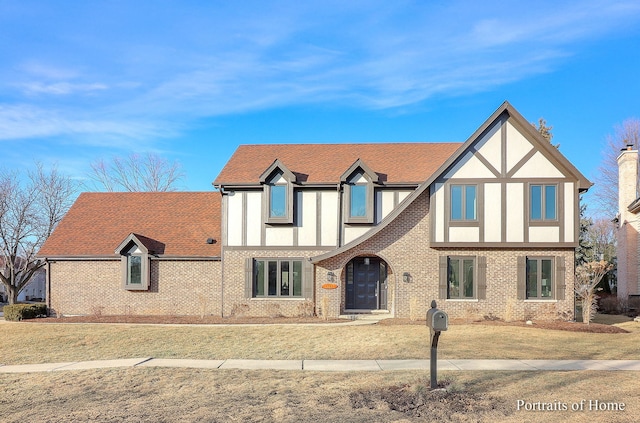 tudor home featuring a front lawn