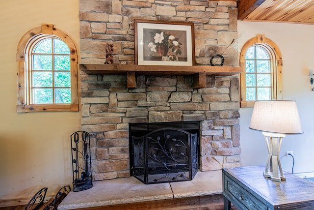 interior details with a stone fireplace, wooden ceiling, and wood-type flooring