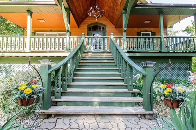 stairway featuring a notable chandelier and wood ceiling