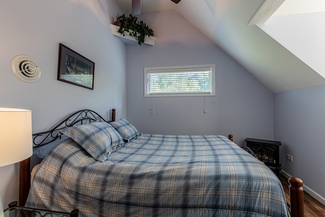 bedroom featuring vaulted ceiling, a wood stove, ceiling fan, and dark hardwood / wood-style floors