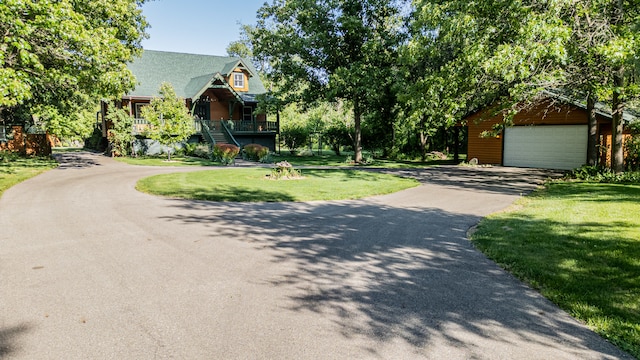 view of front of property with a front lawn, a garage, and an outdoor structure