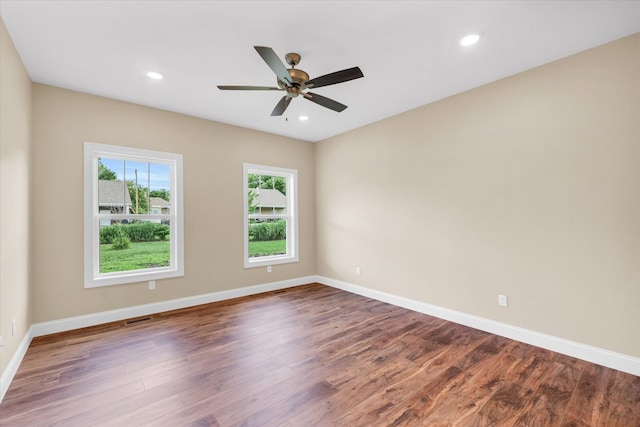 empty room featuring ceiling fan, hardwood / wood-style floors, and plenty of natural light