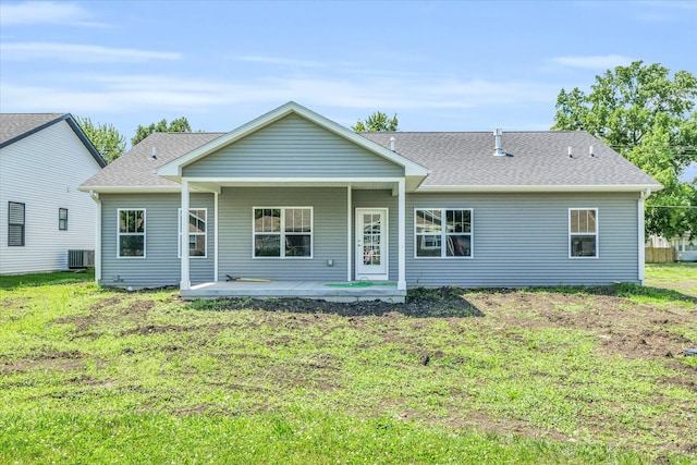 rear view of property with cooling unit, a yard, and a patio area