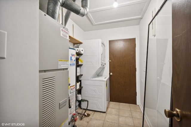 clothes washing area with water heater, stacked washer and dryer, and light tile patterned flooring