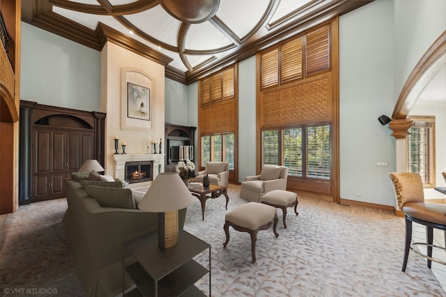 living room with a high ceiling, coffered ceiling, and crown molding