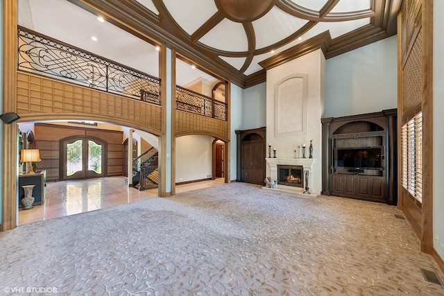 unfurnished living room featuring french doors, tile floors, beam ceiling, a towering ceiling, and coffered ceiling