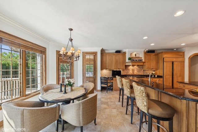 tiled dining room with a wealth of natural light, a chandelier, and crown molding