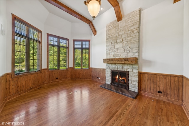 unfurnished living room with a wealth of natural light, a fireplace, and wood-type flooring