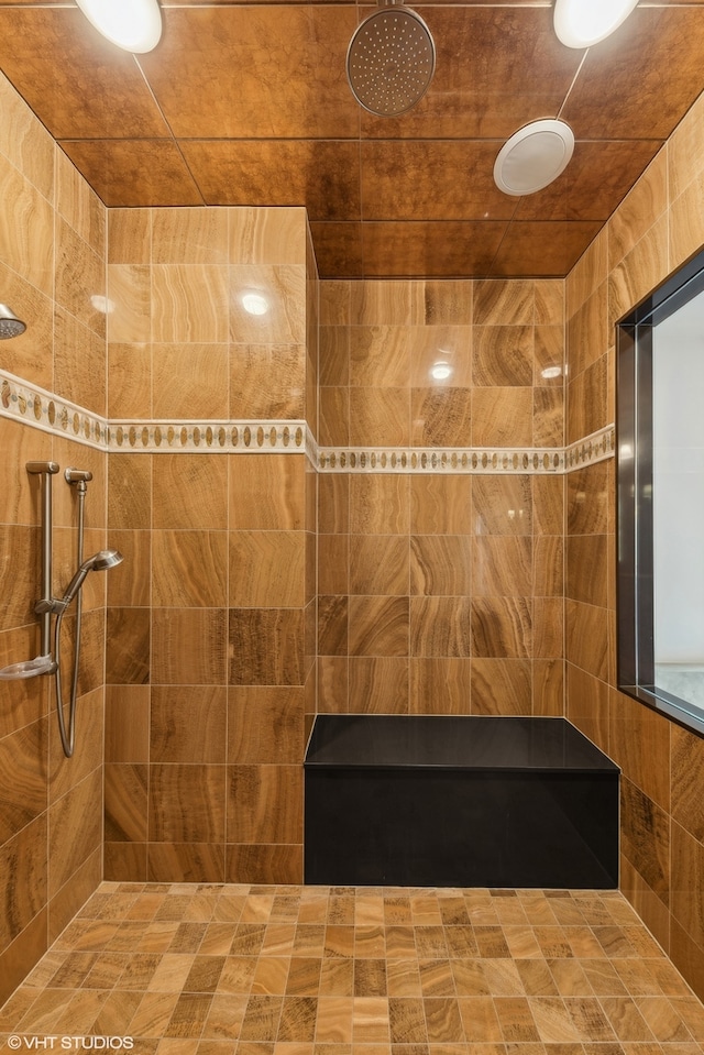 bathroom featuring tiled shower and tile walls