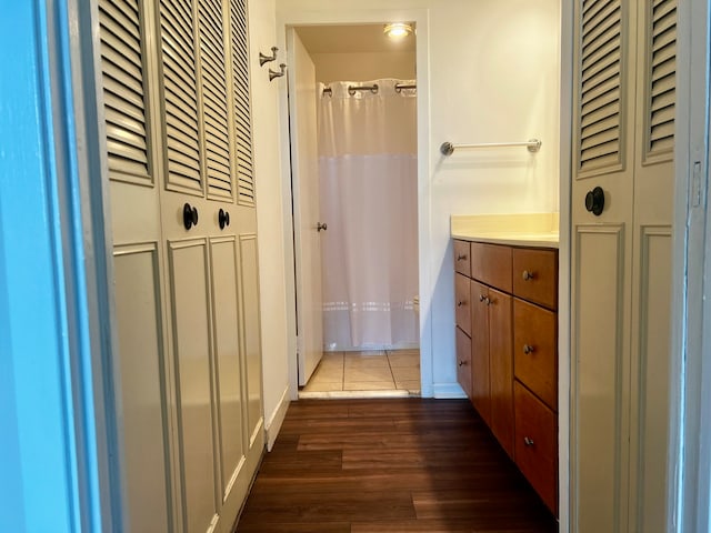 full bathroom with vanity, a shower with shower curtain, wood finished floors, and a closet