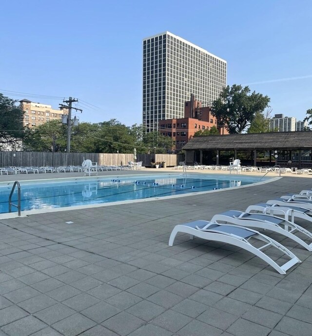 pool with a patio area and fence